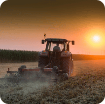 Tracteur qui laboure au coucher du soleil